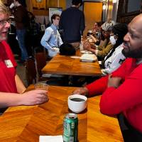 Two alums talk at a booth